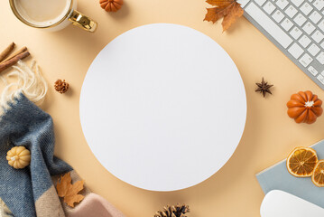 Autumn-themed workplace at home. Top view image of laptop keyboard and mouse, notepad, mug of coffee, scarf, autumnal decorations with space for promotion inside of circle on beige isolated background