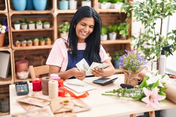 Middle age hispanic woman florist smiling confident counting dollars at florist