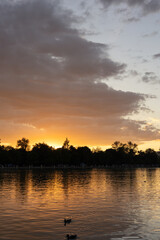 Obraz premium beautiful sunset over the lake with reflection on the water and sky with clouds