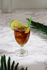 Refreshing peach iced tea cocktail in glass with straw. Summer refreshing fruit drink. Selective focus