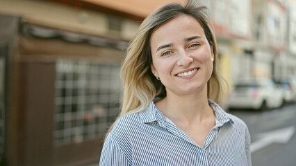 Young blonde woman smiling confident standing at coffee shop terrace