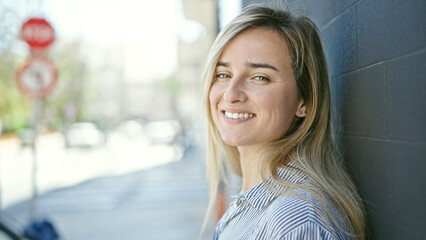 Young blonde woman smiling confident standing at street