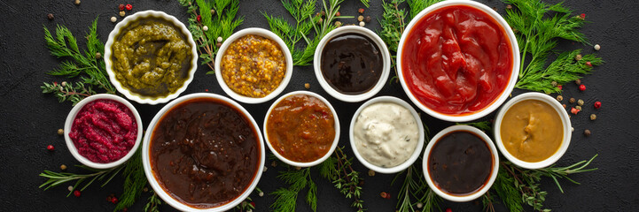 Different types of sauces in bowls with seasonings banner, rosemary and dill, thyme and and peppercorns, top view, copy space