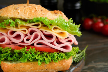 Sandwich. Tasty sandwich with ham or bacon, cheese, tomatoes, lettuce and grain bread on dark...