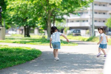 Fototapeta na wymiar 新緑の公園で遊ぶ女の子