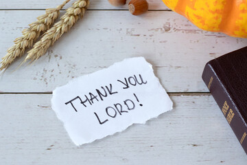 Thank You LORD, handwritten text note with holy bible, pumpkin and ripe wheat stalks on wooden...