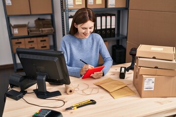 Young blonde woman ecommerce business worker writing on touchpad working at office