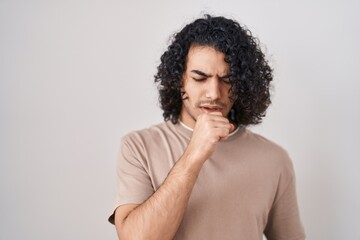 Fototapeta na wymiar Hispanic man with curly hair standing over white background feeling unwell and coughing as symptom for cold or bronchitis. health care concept.
