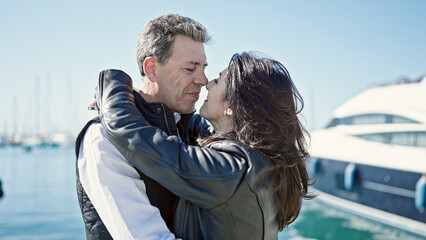 Senior man and woman couple smiling confident hugging each other at port