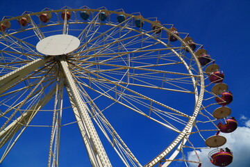 Colorful giant wheel against bright blue sky. Ferris wheel at a spring fairground in Hannover,...