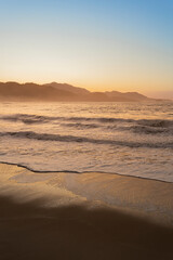 Amanhecer no litoral, sol nascendo atrás da montanha