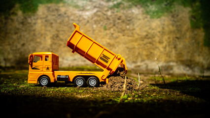 South Minahasa, Indonesia : January 2023, a yellow dump truck toy transporting sand