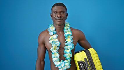 African american man tourist standing shirtless wearing hawaiian lei holding suitcase over isolated...