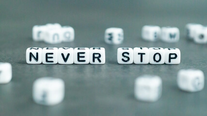 Never stop slogan in white block letter beads. Success and self confidence concept