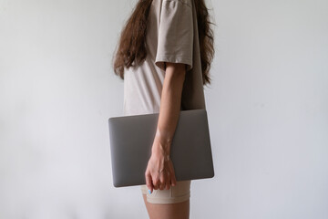 the girl holds a laptop in her hands and goes to work