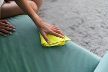 housekeeper wipes sofa with yellow microfiber