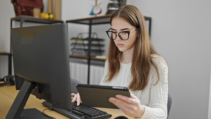 Young hispanic woman business worker using laptop and tablet at office