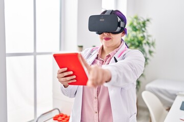 Young beautiful plus size woman doctor using virtual reality glasses at clinic