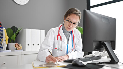 Young caucasian woman doctor using computer working at clinic