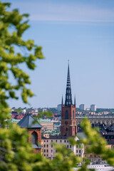 The spire of Riddarholmskyrkan church visible high above rooftops in Stockholm Sweden summertime