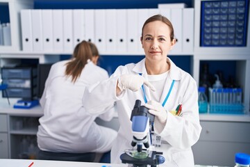 Fototapeta premium Blonde woman working on cruelty free laboratory pointing finger to one self smiling happy and proud