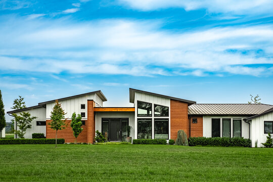 Real Estate Exterior Front House on a sunny day.Big custom made luxury house with nicely landscaped front yard in summer
