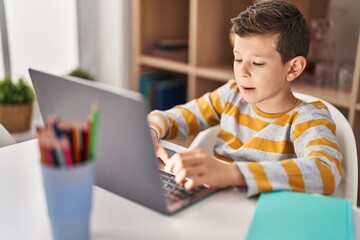 Blond child studying sitting on table at home