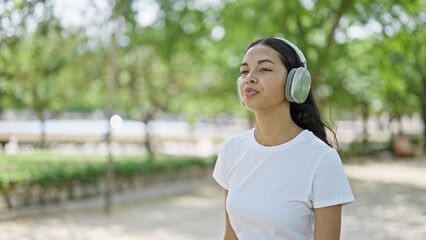 African american woman listening to music walking at park