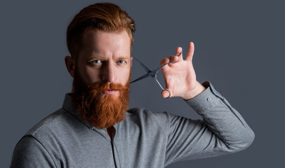 man portrait in hairdresser studio. man hold hairdresser scissors for haircut. concept of mens...