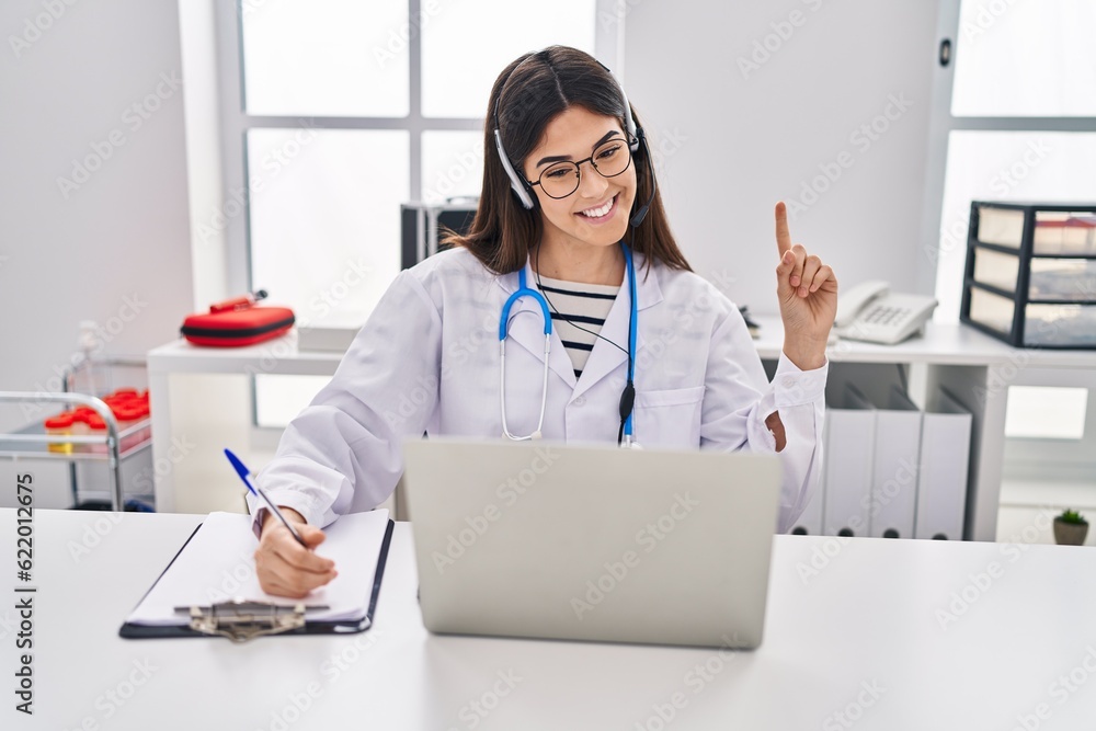 Poster young brunette woman working on online appointment smiling with an idea or question pointing finger 