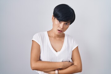 Obraz premium Young asian woman with short hair standing over isolated background in shock face, looking skeptical and sarcastic, surprised with open mouth