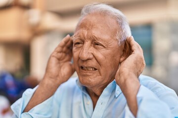 Senior grey-haired man suffering for no listening at street