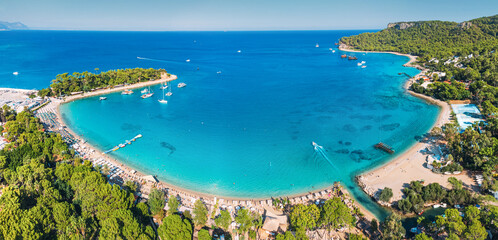 aerial paradise view, showcasing an idyllic harbor adorned with luxurious yachts and green forest...