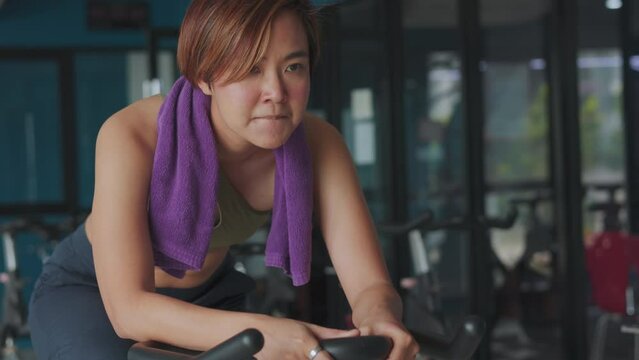 Muscle definition and determination of a short-haired beautiful Asian woman who epitomizes the meaning of strength and athleticism. Her fierce determination face is evident in every movement.