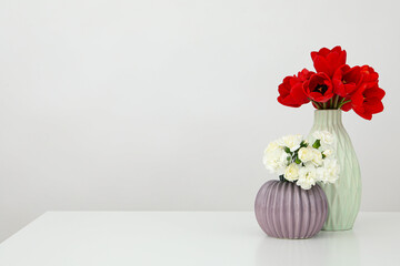 Two vases with flowers on the table with space for text