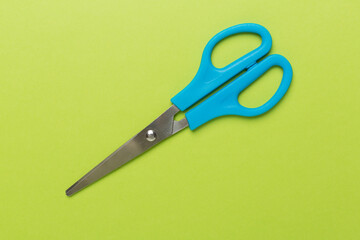 Blue scissors on color backgroung, top view