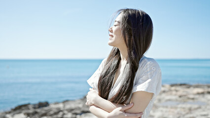 Fototapeta na wymiar Young chinese woman breathing with closed eyes at seaside