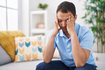 Young man stressed sitting on sofa at home