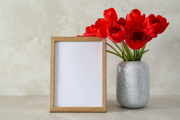 Photo frame with flowers on the table with empty space