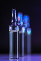 three glass ampoules with injection solution, close-up, selective focus
