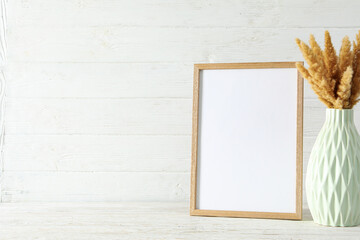 Photo frame with flowers on the table with empty space