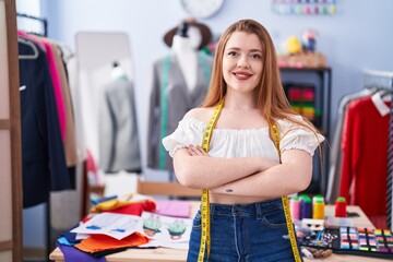 Young redhead woman tailor smiling confident standing with arms crossed gesture at clothing factory