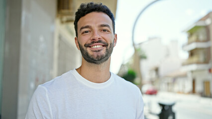 Obraz premium Young hispanic man smiling confident standing at street