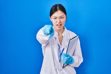 Chinese young woman working at scientist laboratory pointing displeased and frustrated to the...