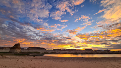 Panoramic view at sunset on solitary rock formations Lone Rock in Wahweap Bay in Lake Powell in...