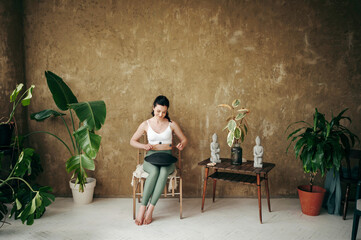 Young attractive woman playing on tank drum indoors
