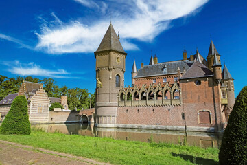 Beautiful dutch romantic fairy tale castle with towers, green garden park, blue summer sky -...