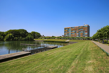 Beautiful swimming lake landscape on outskirts of city, jetties, green meadow, lakeside residential...