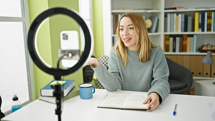 Young blonde woman student recording video tutorial at library university