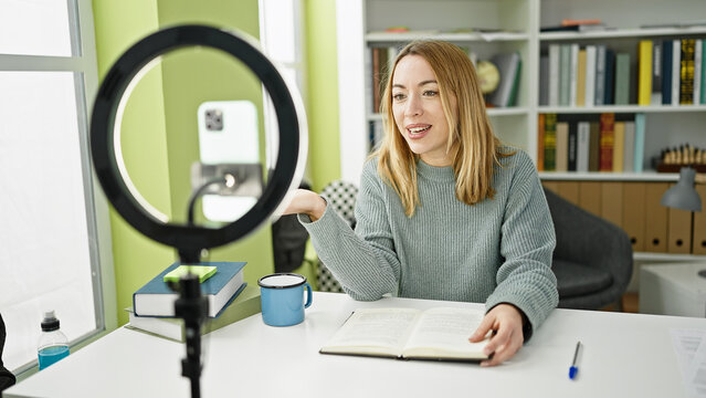 Young blonde woman student recording video tutorial at library university